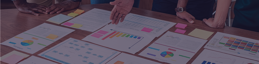 Several people discussing charts on table for important meeting