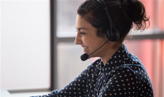 Happy sales staff answering customer calls with headset